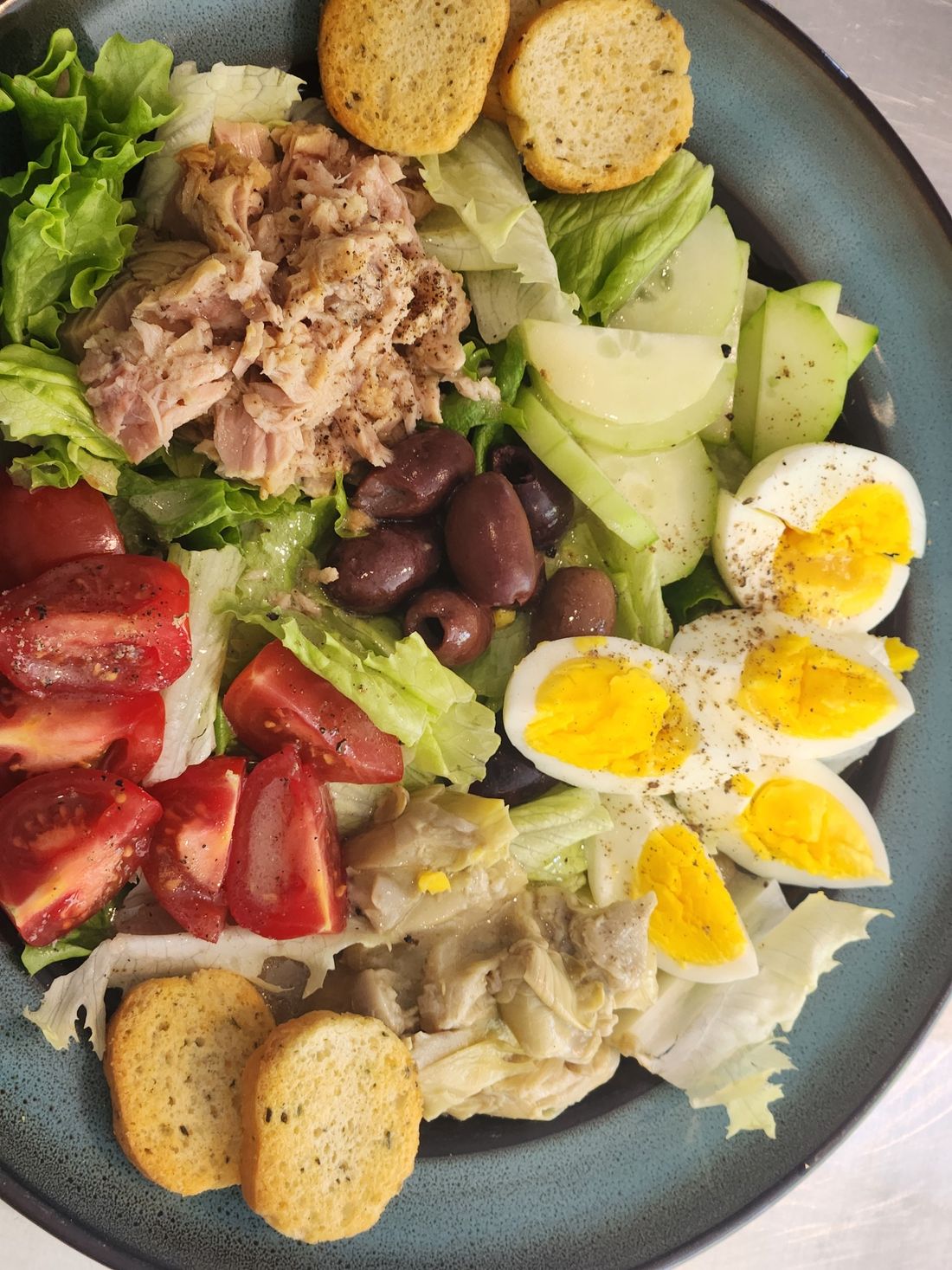 Salad Niçoise with tuna, hard-boiled eggs, tomatoes, olives, cucumber and toasted bread